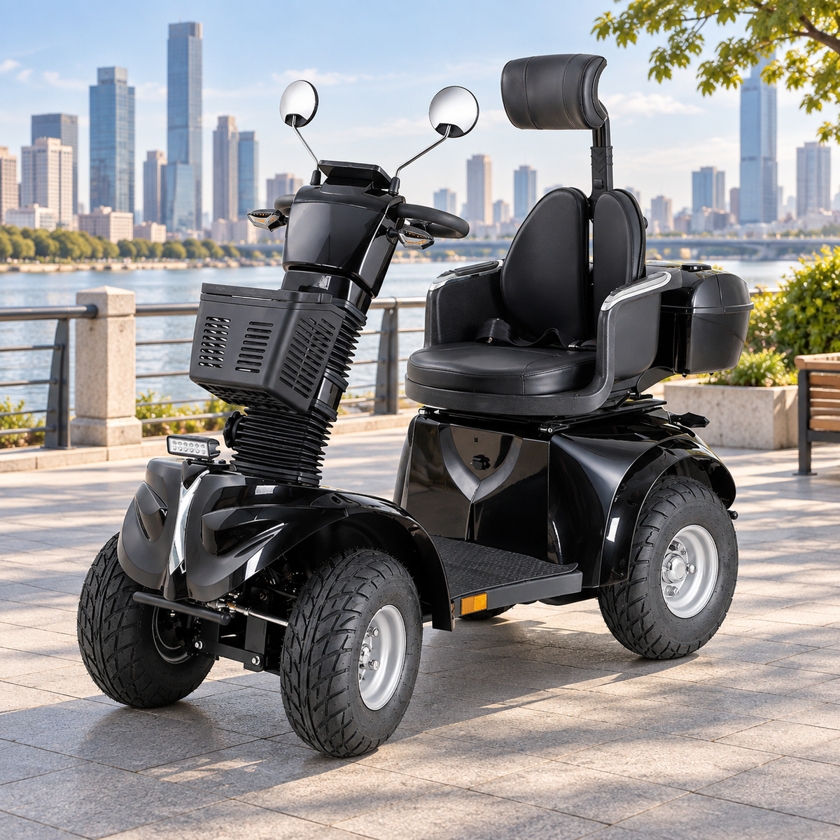 Black Hubsite heavy duty mobility scooter with headrest, front basket and lockable rear box on a riverside promenade